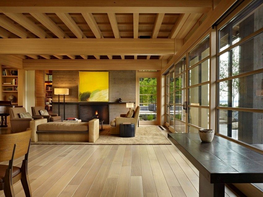 The interior of the living room with panoramic glazing in the house of glued beams