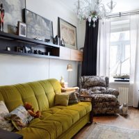 Sofa with olive upholstery in the hall with black curtains