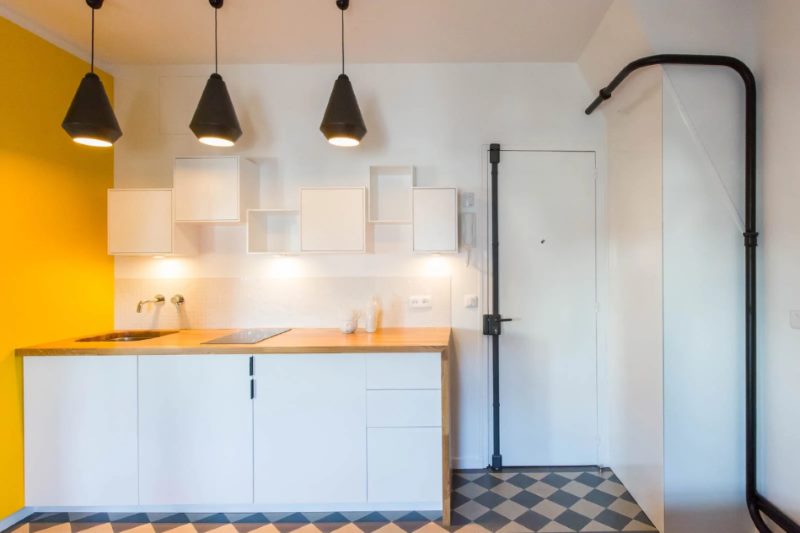 Black pipes in the interior of a white kitchen