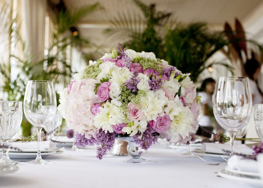 Bouquet dengan bunga tiruan di atas meja perayaan.