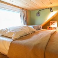 Bedroom with a low ceiling in the attic of a country house