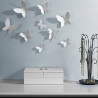 White paper butterflies on a blue wall