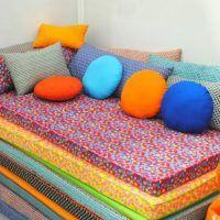 Bright pillows made of multi-colored material for sofa decor