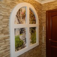 Window with an arch on the wall of the hallway in a panel house