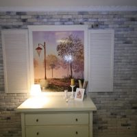 White chest of drawers against a brick wall