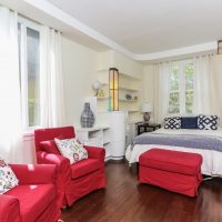 A contrasting combination of red armchairs with white walls