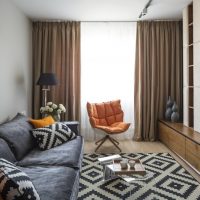 Brown curtains on the window of an elongated living room