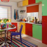 Striped carpet in the kitchen with colored facades.