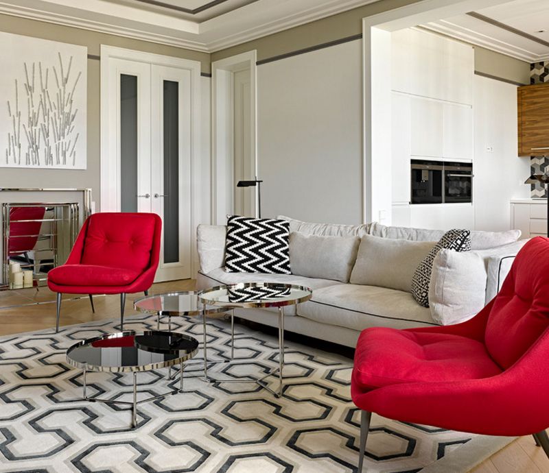 Two red chairs on the carpet with a geometric pattern