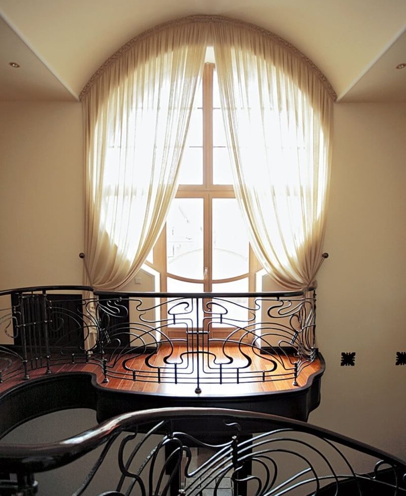 Round window with a door to the balcony of a private house