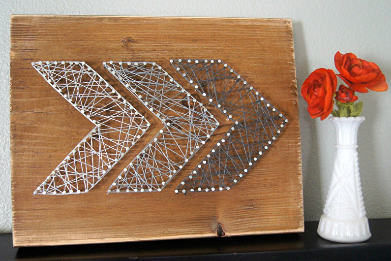 Panel of threads and carnations on a wooden panel