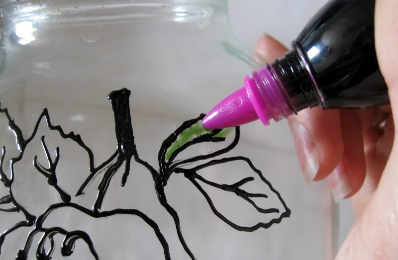 Putting green paint on a jar using a tube