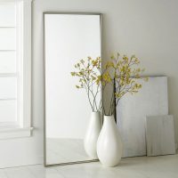 Thin-frame floor vase in front of a mirror