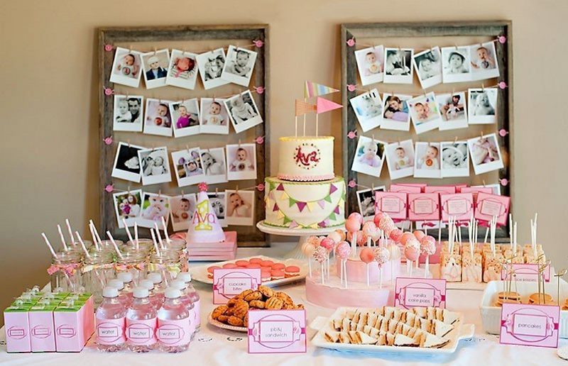 Decorating a wall over a festive table with baby photos