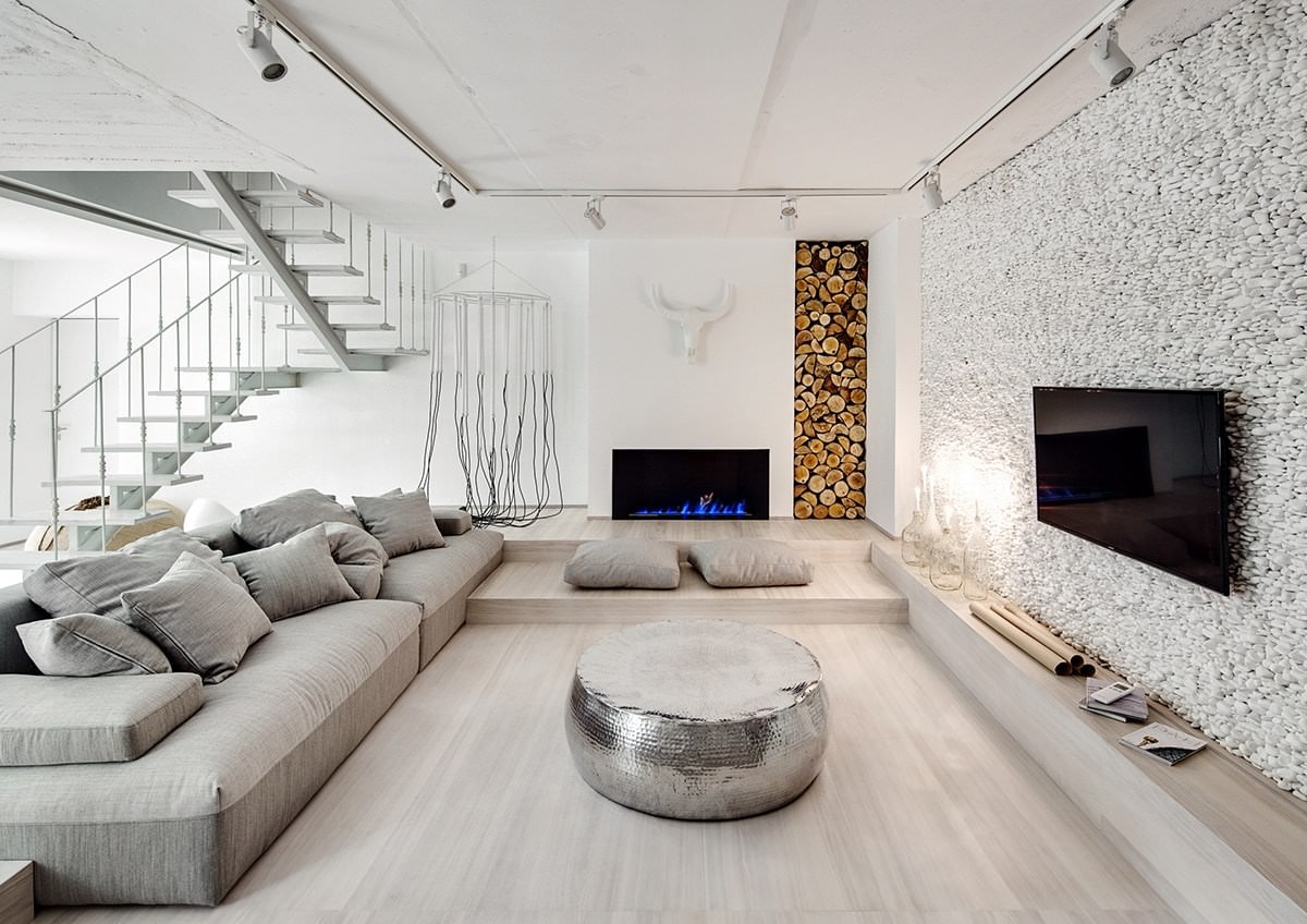 Interior of a studio apartment in white with an imitation of a fireplace