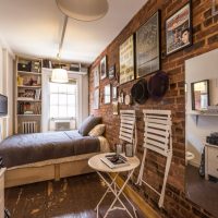 Narrow bedroom interior with brick wall