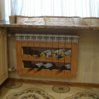 Painted heating radiator under shelves with wine bottles