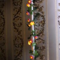 Garland with flowers on a heating pipe