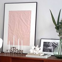 A sheet of crumpled paper framed on a chest of drawers