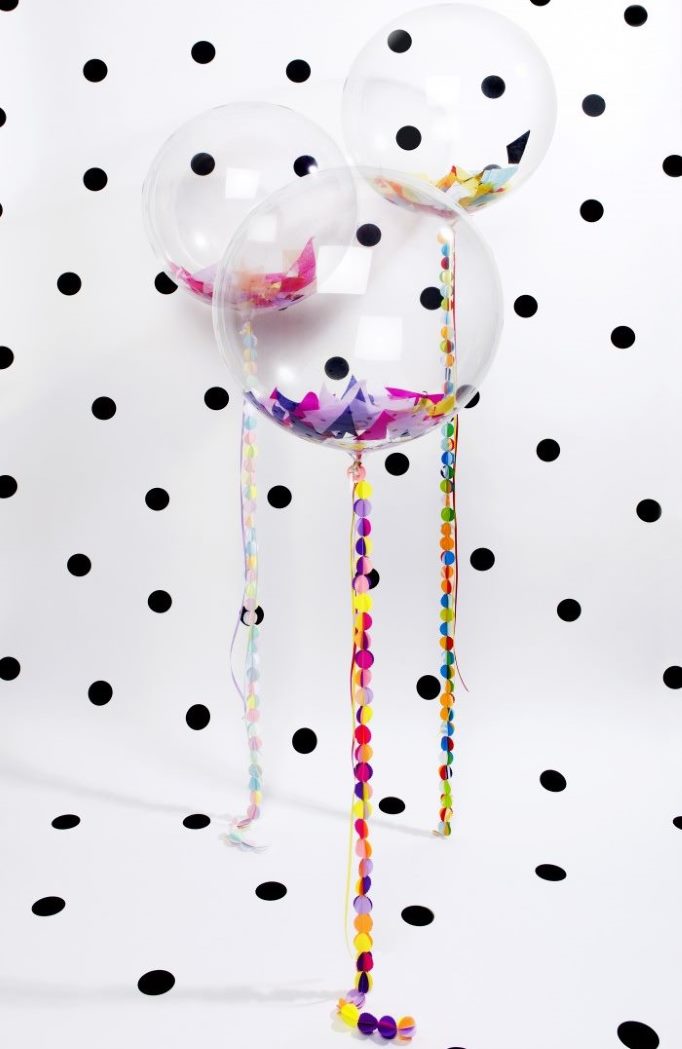 Transparent helium balloons with confetti inside.