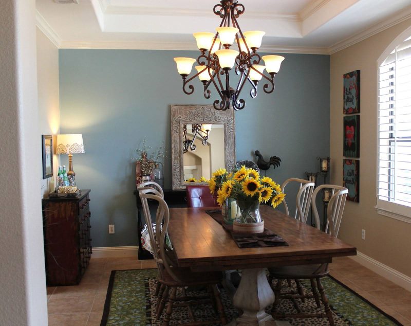 Chandelier with wrought iron elements over the dining table in the living room of a private house.