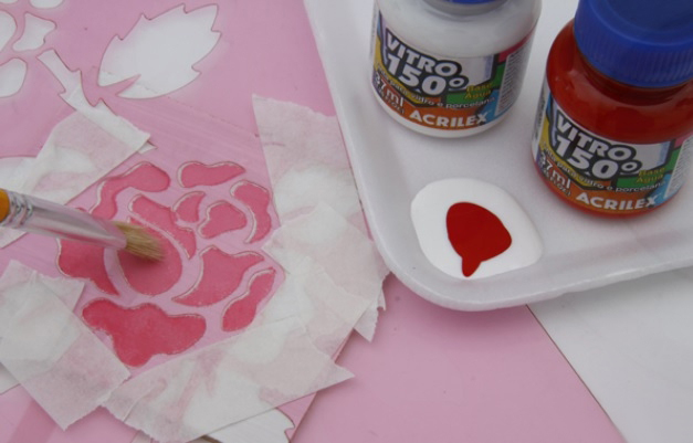 Application of paint on the surface of the mirror through a stencil