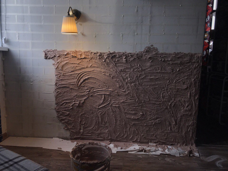 Application of decorative plaster on a concrete wall