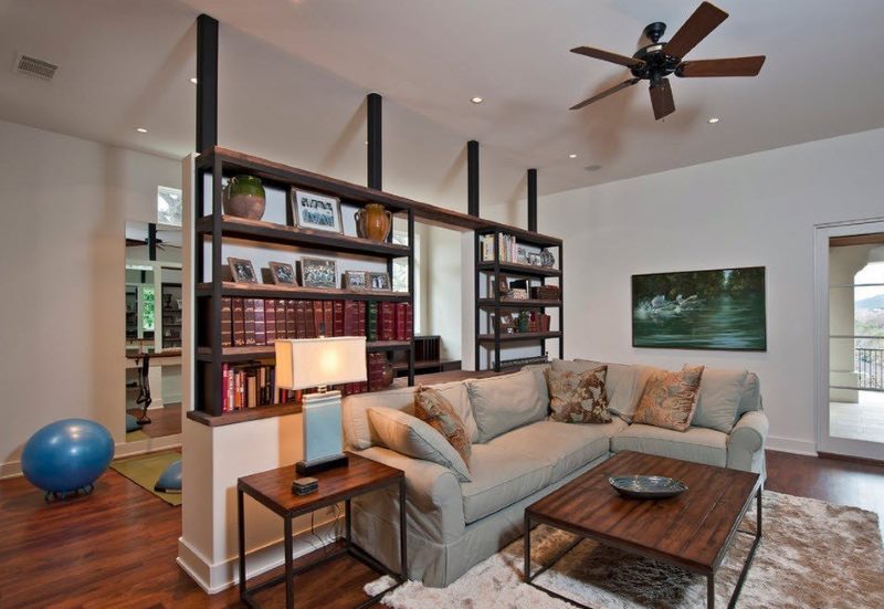 Zoning of the living room with a shelf with bookshelves