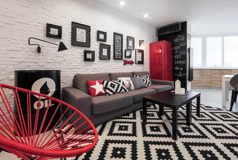 Red fridge next to a gray sofa