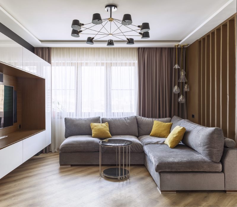 Gray corner sofa in the living room interior