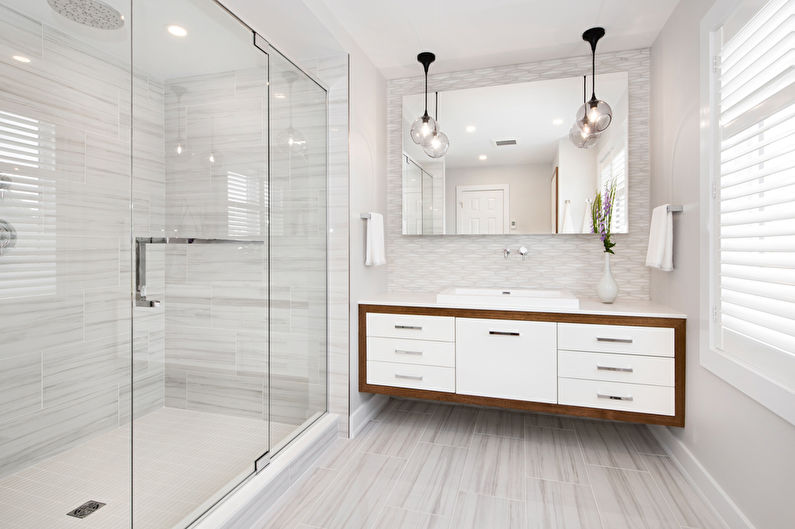 Two pendant lights above a large bathroom mirror