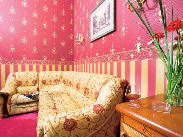 To give the room retro motifs, it is recommended that the lower part of the room be glued with wallpaper in a vertical strip, and the upper border is framed.